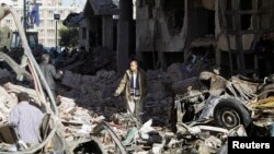 A man walks near debris after an explosion near a security building in Egypt's Nile Delta city of Mansoura in Dakahlyia province, about 120 km (75 miles) northeast of Cairo, Dec. 24, 2013.