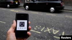 FILE - A photo illustration shows the Uber app logo displayed on a mobile telephone, as it is held up for a posed photograph in central London, Britain October 28, 2016.
