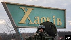 Tentara Ukraina tampak berjaga di area pemeriksaan bersama dengan agen keamanan Ukraina dan polisi dalam operasi bersama di Kharkiv, Ukraina, pada 17 Februari 2022. (Foto: AP/Evgeniy Maloletka)