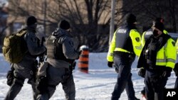 Policija u Otavi uklanja blokadu koju su postavile kamiondžije za vreme protesta zbog pandemijskih restrikcija, u petak, 18. februara 2022.