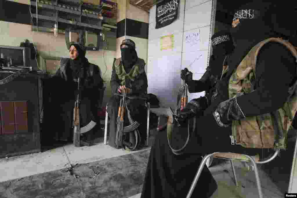 Women members of the Al-Ikhlas (Loyalty) Battalion rest with their weapons in Aleppo, Syria, March 31, 2013.