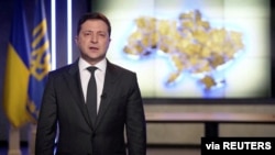 Presiden Ukraina Volodymyr Zelenskiy berbicara dalam Bahasa Rusia saat menyampaikan perkembangan situasi di Kyiv, Ukraina, pada 24 Februari 2022. (Foto: Ukrainian Presidential Press Service/via Reuters TV/Handout via Reuters)