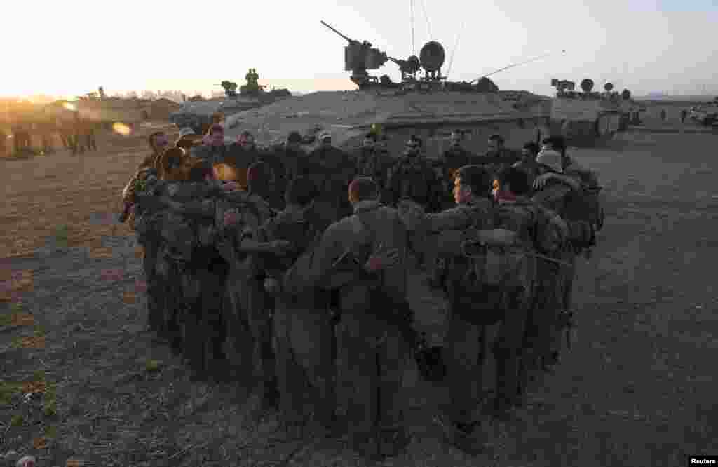 Israeli soldiers from the Golani Brigade stand in a circle at a staging area before entering Gaza from Israel, July 30, 2014. 