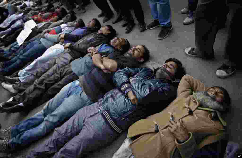 Indian men and women lie down on the ground mimicking dead bodies as they mourn the death of a gang rape victim in New Delhi, Saturday, Dec. 29, 2012.