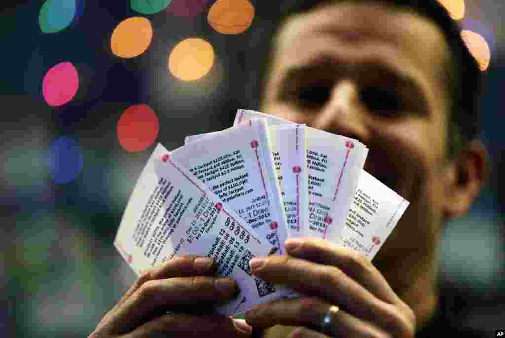 Chad Cuneo memperlihatkan tiket lotre Mega Millions yang dibelinya di sebuah kios di Philadelphia, Pennsylvania. Tahyul tidak mencegah para pemain lotre dari harapan mereka memperoleh keberuntungan walaupun hari ini adalah Jumat tanggal 13.