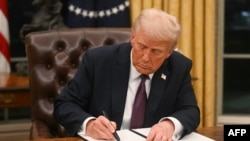 Picha ya maktaba ya Trump akitia saini amri ya kiutendaji. January 20, 2025. (Photo by Jim WATSON / POOL / AFP)