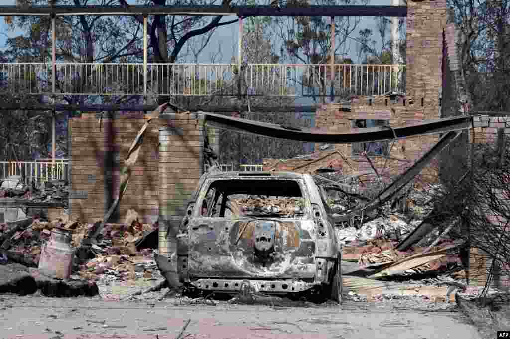 Rumah dan kendaraan yang terbakar daerah pinggiran kota Blue Mountains di Winmalee, sebelah barat Sydney (21/10).