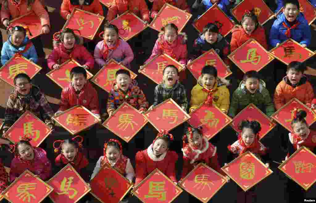 2013年12月31日,在马年之前,江西九江一所小学的孩子们展示他们的剪纸作品“马”字。