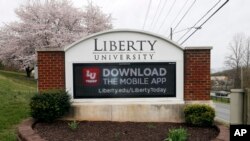 A sign marks the entrance to Liberty University, March 24 , 2020, in Lynchburg, Va. Officials in Lynchburg said they were fielding complaints and concerns about the hundreds of students that have returned.