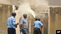 Polisi berpatroli sementara petugas pemadam kebakaran berusaha memadamkan api di gereja Salvation Army sesudah gereja tersebut dibakar oleh perusuh di Mombasa, Kenya, 4/10/2013. 