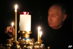 Russian President Vladimir Putin lights a candle to commemorate victims of a March 22 attack on the Crocus City Hall concert venue, on the day of national mourning, March 24, 2024. (Mikhail Metzel/Sputnik/Kremlin Pool/via AP)