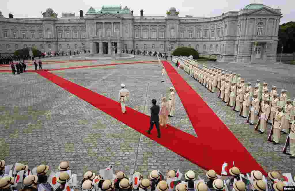 Bangladesh's Prime Minister Sheikh Hasina (center, R) and Japan's Prime Minister Shinzo Abe (centre, L) walk as they attend a welcoming ceremony at the state guest house in Tokyo.