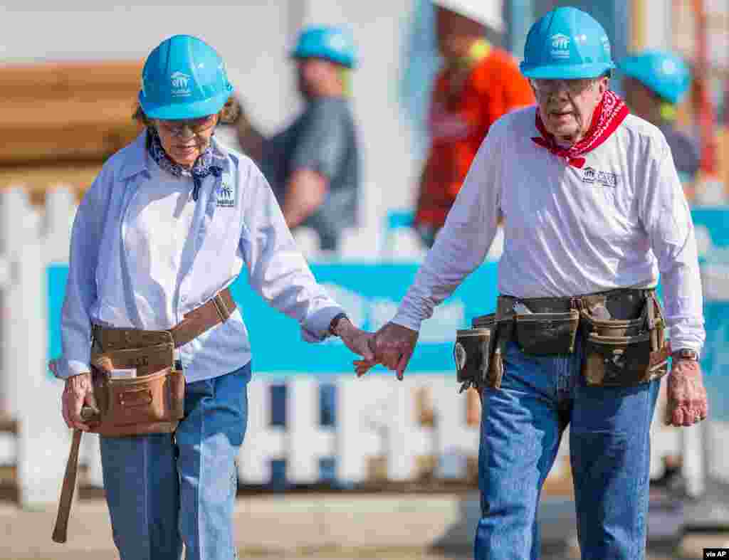 Former President Jimmy Carter holds hands with his wife Rosalynn Carter as they work with other volunteers for Habitat for Humanity in Mishawaka, Indiana, Aug. 27, 2018. (Robert Franklin/South Bend Tribune)
