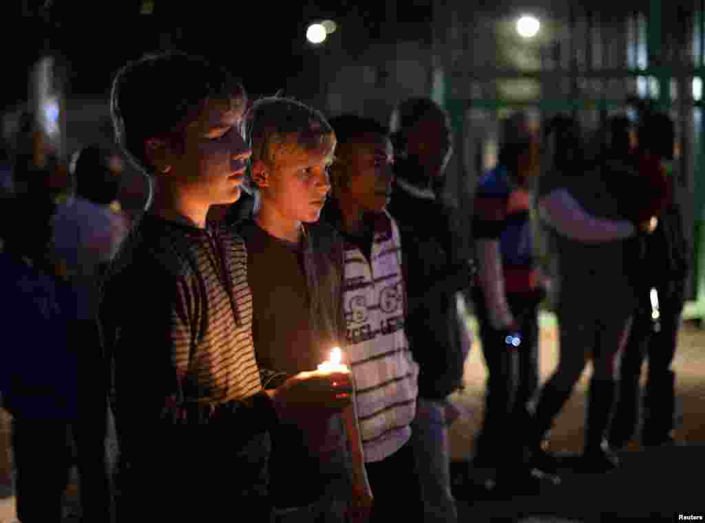 Boys hold a candle as they pay their respects outside the Mediclinic Heart Hospital, where ailing former South African President Nelson Mandela is being treated in Pretoria, July 1, 2013.