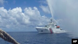 2015年9月23日,中國海岸防衛隊成員在南中國海的斯卡伯勒淺灘(Scarborough Shoal)附近與菲律賓漁民對峙。(美聯社)