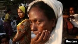 FILE - Rohingya people wait to receive their share of food aid from the World Food Program (WFP) at the Thae Chaung camp for internally displaced people in Sittwe, Rakhine state.