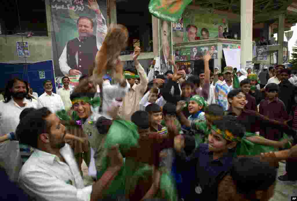 Supporters of Pakistan's former Prime Minister Nawaz Sharif celebrate after initial results from parliamentary elections put his party in the lead, Islamabad, May 12, 2013.