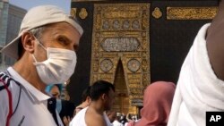 A relatively few number of Muslims pray around the Kaaba, the cubic building at the Grand Mosque, in the Muslim holy city of Mecca, Saudi Arabia, Thursday, March 5, 2020.
