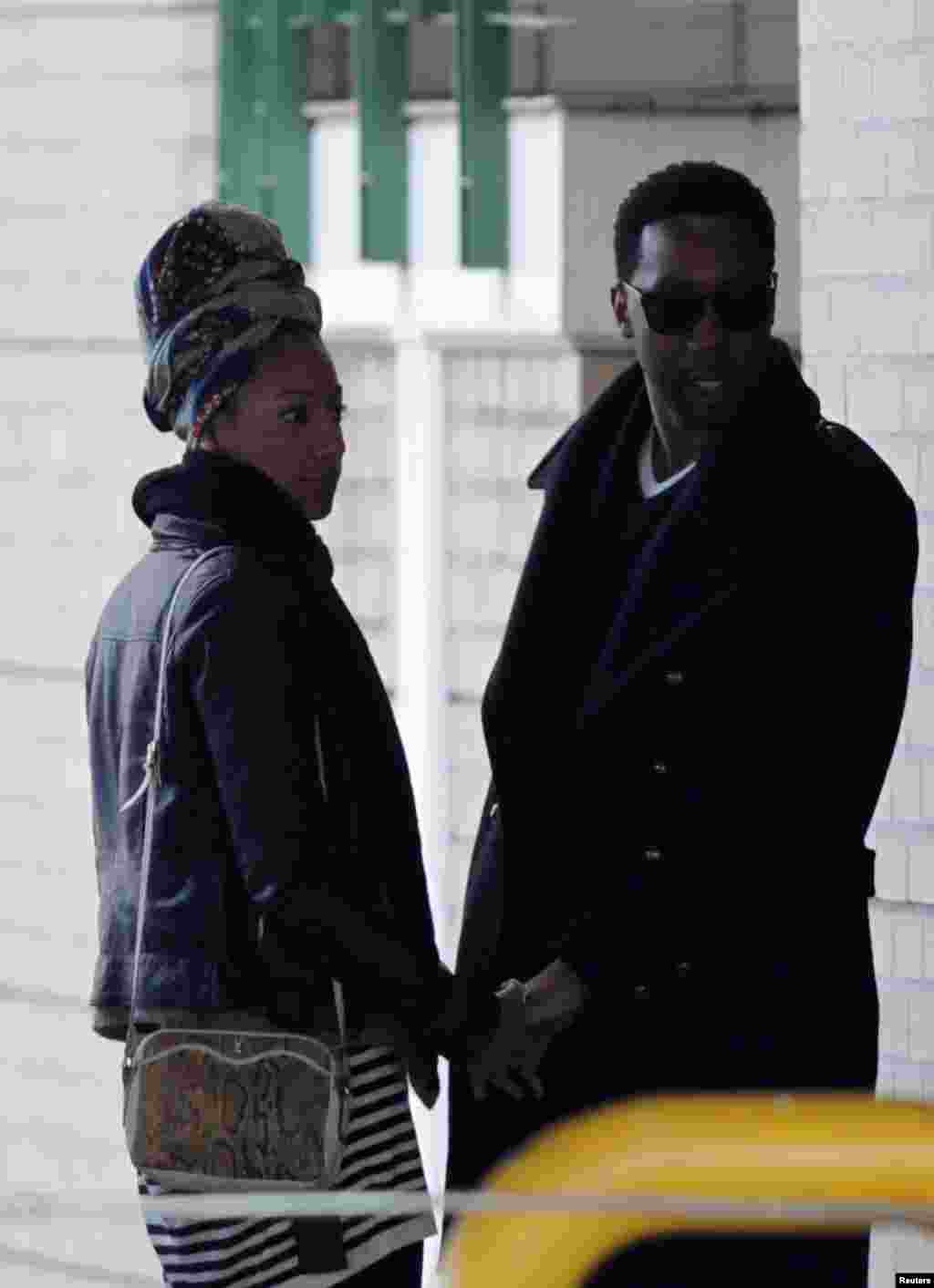 Ndaba Mandela (R), one of former South African President Nelson Mandela's grandsons, and an unidentified companion leave the Mediclinic Heart Hospital, where the former president is being treated, in Pretoria, July 5, 2013. 