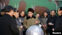 김정은 북한 국방위원회 제1위원장이 핵무기 연구 부문 과학자, 기술자들을 만나 핵무기 병기화 사업을 지도하는 모습을 2016년 3월 조선중앙통신이 보도했다. 사진 아래쪽에 핵탄두 기폭장치 추정 물체가 보인다.