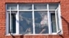 FILE - A family watches from a window as people carry the body of a local Pandit businessman killed by suspected anti-Indian gunmen a day before, during his funeral in Srinagar, Indian-administered Kashmir, Oct. 6, 2021. 