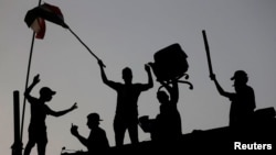 Irački demonstranti stoje na betonskom zitu tokom antivladinih protesta u blizini vladine zgrade u Basri, Irak, 7. septembra 2018.