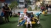 Niños con tapabocas juegan en un rueda en un parque en Caracas, Venezuela. Julio 17, 2020