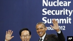 South Korea's President Lee Myung-bak (L) poses with U.S. President Barack Obama as he arrives for a working dinner at the Nuclear Security Summit at the Convention and Exhibition Center in Seoul, March 26, 2012.