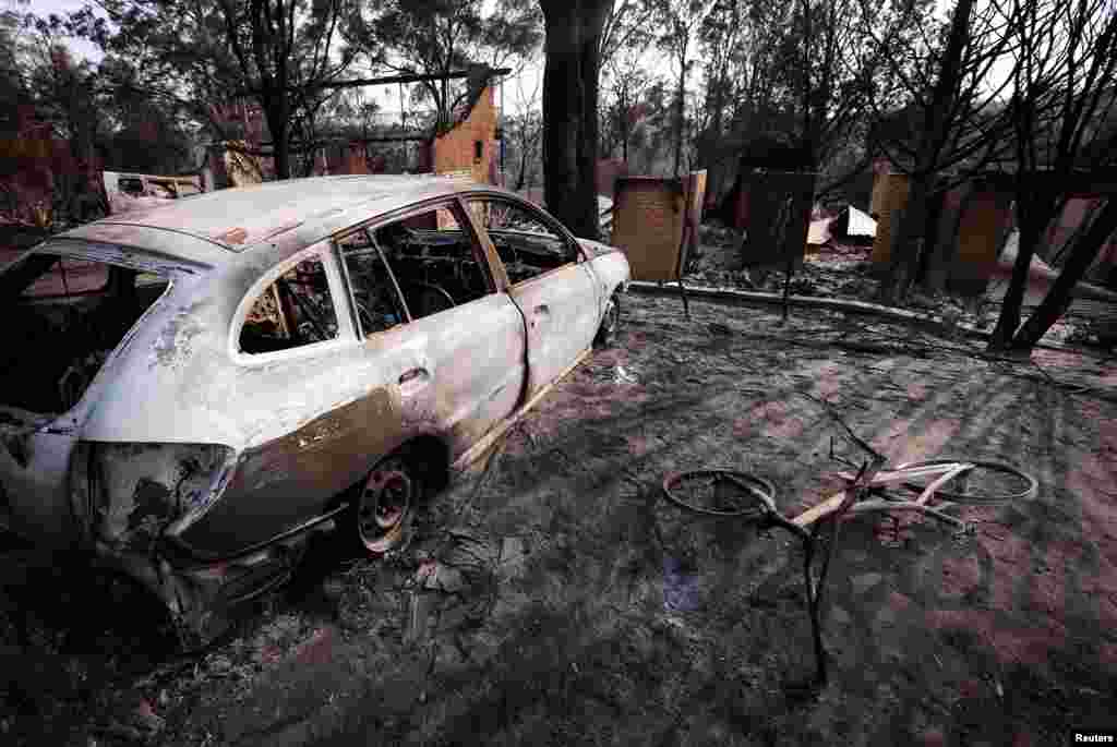 Rumah-rumah dan kendaraan yang terbakar daerah pinggiran kota Blue Mountains di Winmalee, sebelah barat Sydney (21/10).