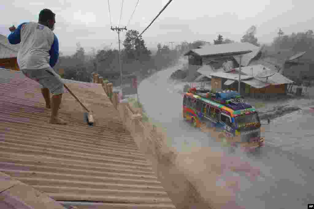 Seorang laki-laki menyapu abu vulkanik di atap rumahnya yang berasal dari letusan Gunung Sinabung di Sibintun, Sumatera Utara. Gunung berapi itu telah melakukan erupsi sejak bulan September, memaksa lebih dari 20.000 orang yang tinggal di sekitar lereng gunung itu mengungsi ke beberapa tempat penampungan sementara.