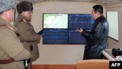 金正恩在觀看導彈試射期間與官員談話。（2022年1月11日）