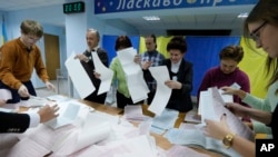 Members of a local election commission count ballots at a polling station in Kyiv, Ukraine, Oct. 25, 2015.