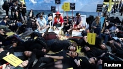 Human rights activists stage a protest on a sandy beach to call on EU leaders to do more to protect the rights and lives of migrants, refugees and asylum seekers arriving at Europe's borders, ahead of a European Union leaders summit in Brussels, March 20,