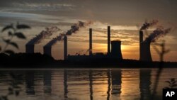 FILE - The coal-fired Plant Scherer, one of the top carbon dioxide emitters in the U.S., stands in the distance in Juliette, Georgia, June, 3, 2017.