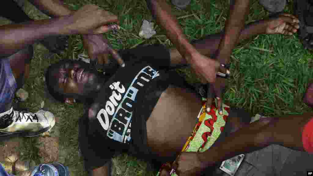 Un homme atteint par balle attend l'arrivée d'une ambulance à Musaga, un quartier de Bujumbura, le 21 mai 2015.
