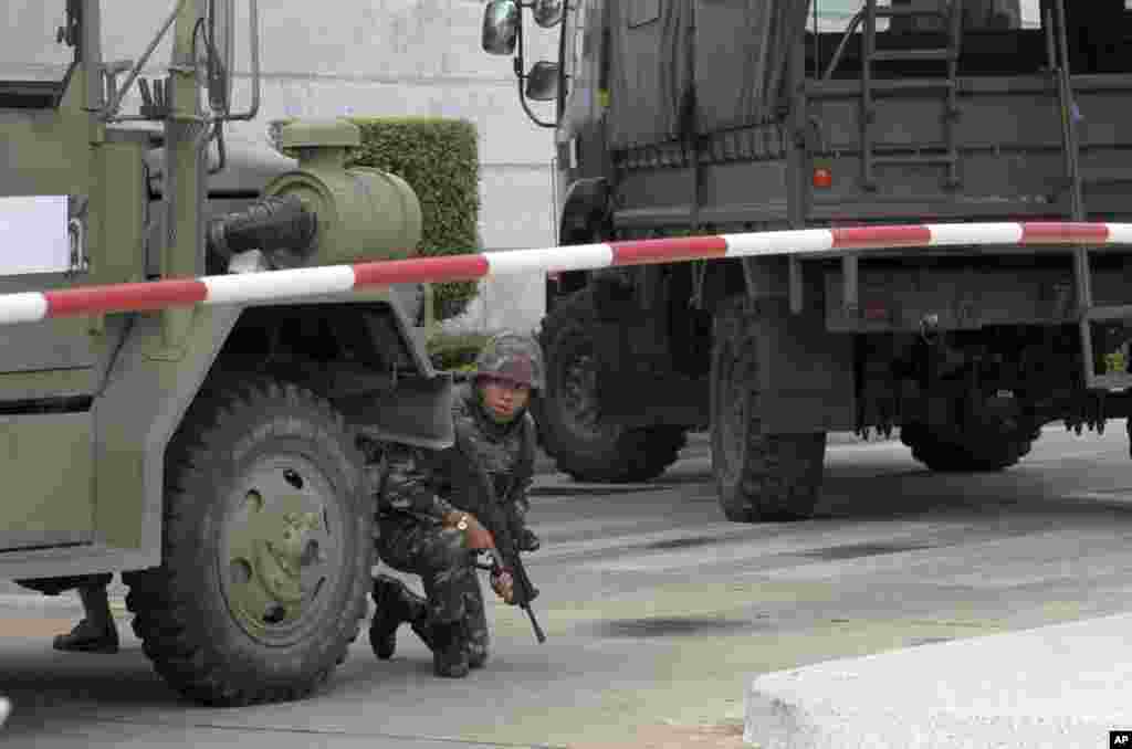 An armed soldier takes a position behind a military vehicle in the compound of the Army Club shortly after the military staged a coup, in Bangkok, May 22, 2014.