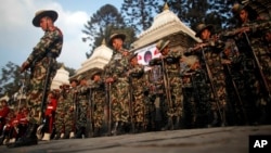 FILE - Nepalese army soldiers give a guard of honor during the cremation of Nepalese prime minister Sushil Koirala, on the banks of the Bagmati River in Kathmandu, Nepal. Nepal will hold its first-ever military exercise with China next month. 