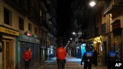 FILE - Police officers patrol a street before closing all bars and restaurants at 10 p.m. due to the new measures to prevent the spread of the coronavirus, in Pamplona, northern Spain, Oct. 16, 2020. (AP)