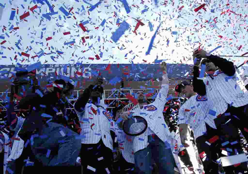 Chicago Cubs' Jon Lester holds the Commissioners Trophy as he celebrates with teammates during a celebration honoring the World Series champions at Grant Park in Chicago, llinois.