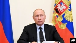 FILE - Russian President Vladimir Putin attends a meeting via video conference at the Novo-Ogaryovo residence outside Moscow, Russia, June 10, 2020. 
