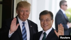 도널드 트럼프 미국 대통령(왼쪽)이 30일 워싱턴 백악관에서 문재인 한국 대통령을 영접한 후 취재진을 향해 함께 손을 흔들고 있다.
