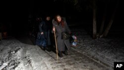 Žene sa prtljagom prelaze granicu sa Rusijom u ukrajinskom regionu Sumi (Foto: AP/Hanna Arhirova)