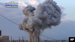 This image taken from video provided by the Syrian activist-based media group Syrian Revolutionary Command Council in Hama, which has-been verified and is consistent with other AP reporting, shows smoke rising after a Russian airstrike hit buildings in th