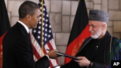 El presidente Barack Obama entrega al presidente afgano Hamid Karzai el histórico acuerdo estratégico firmado por ambos mandatarios.