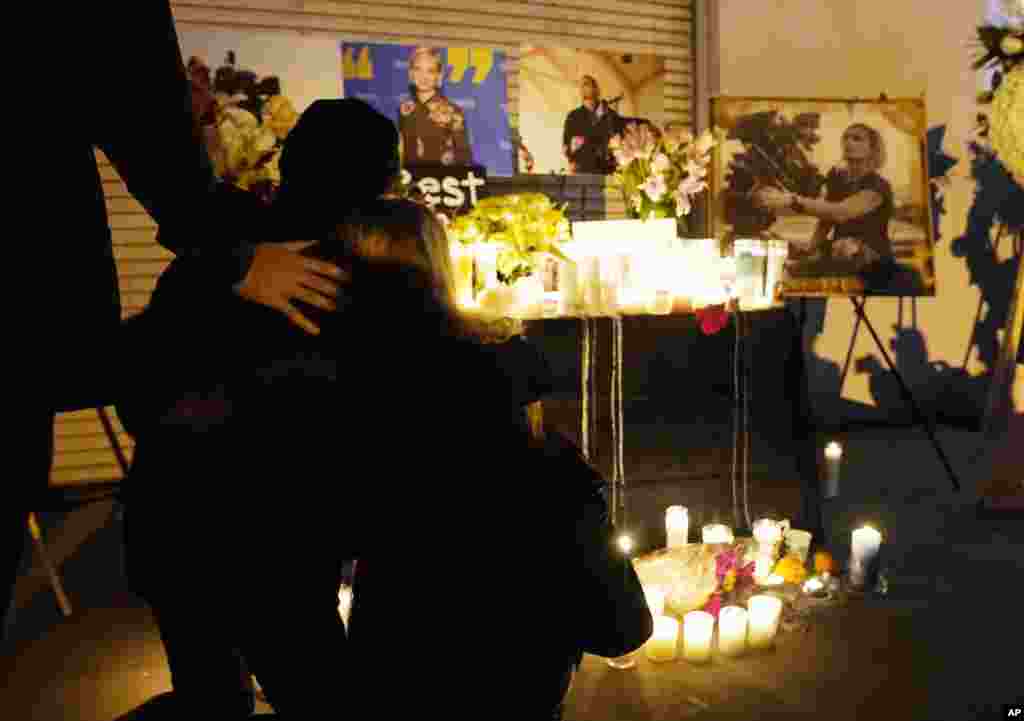 Attendees embrace at a candlelight vigil for the late cinematographer Halyna Hutchins, Oct. 24, 2021, in Burbank, California. A prop firearm discharged last Thursday by actor Alec Baldwin, while producing and starring in a Western movie in Santa Fe, New Mexico, killed Hutchins and wounded director Joel Souza.