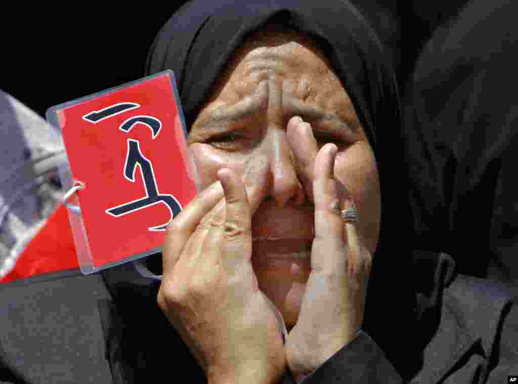 An Egyptian protester shouts anti-President Mohamed Morsi slogans and holds a red card that reads "leave" in Arabic during a protest in Tahrir Square, Cairo, June 28, 2013.