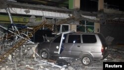  Debris from a building of Surigao State College and Technology is seen on a car after an earthquake hit Surigao city, southern Philippines, Feb. 10, 2017.