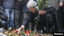 El secretario de Estado de EE.UU., John Kerry, prende una vela en el parque Independence Square, en Kiev, donde murieron decenas de protestantes en las marchas antigubernamentales de las semanas pasadas.
