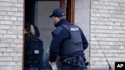 Danish police are seen entering an apartment as part of an operation that resulted in the arrest of four suspected Islamic State recruits, in Tingbjerg, Copenhagen, Denmark, Apr. 7, 2016.