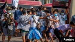 Seorang pendukung militer membawa senjata tajam saat berhadapan dengan pengunjuk rasa pro-demokrasi dalam aksi unjuk rasa di Yangon, Myanmar, 25 Februari 2021.